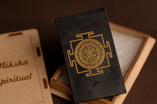 Black book with gold geometric design on a wooden surface, with 'Niksha spiritual' branding.